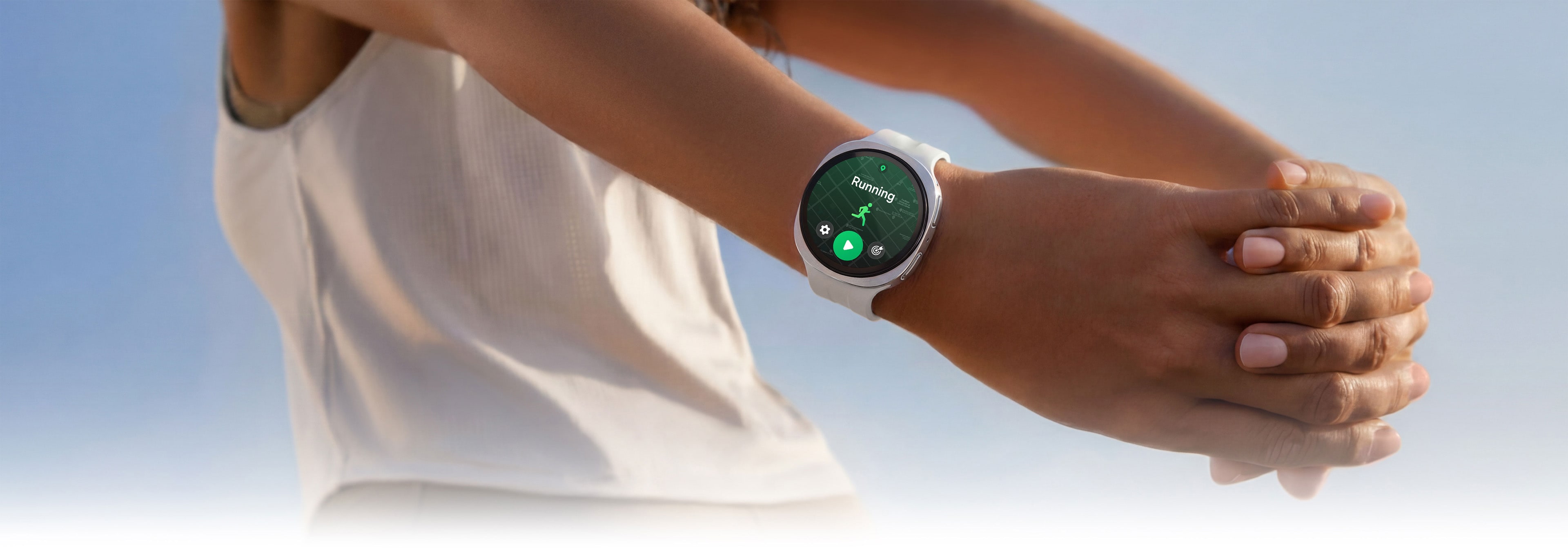 Zu sehen ist eine Person, die ihre Arme dehnt und eine Galaxy Watch9 in Cream mit einem Sport Band in Cream trägt. Auf dem Display der Uhr ist das Running-Coach-Programm geöffnet.