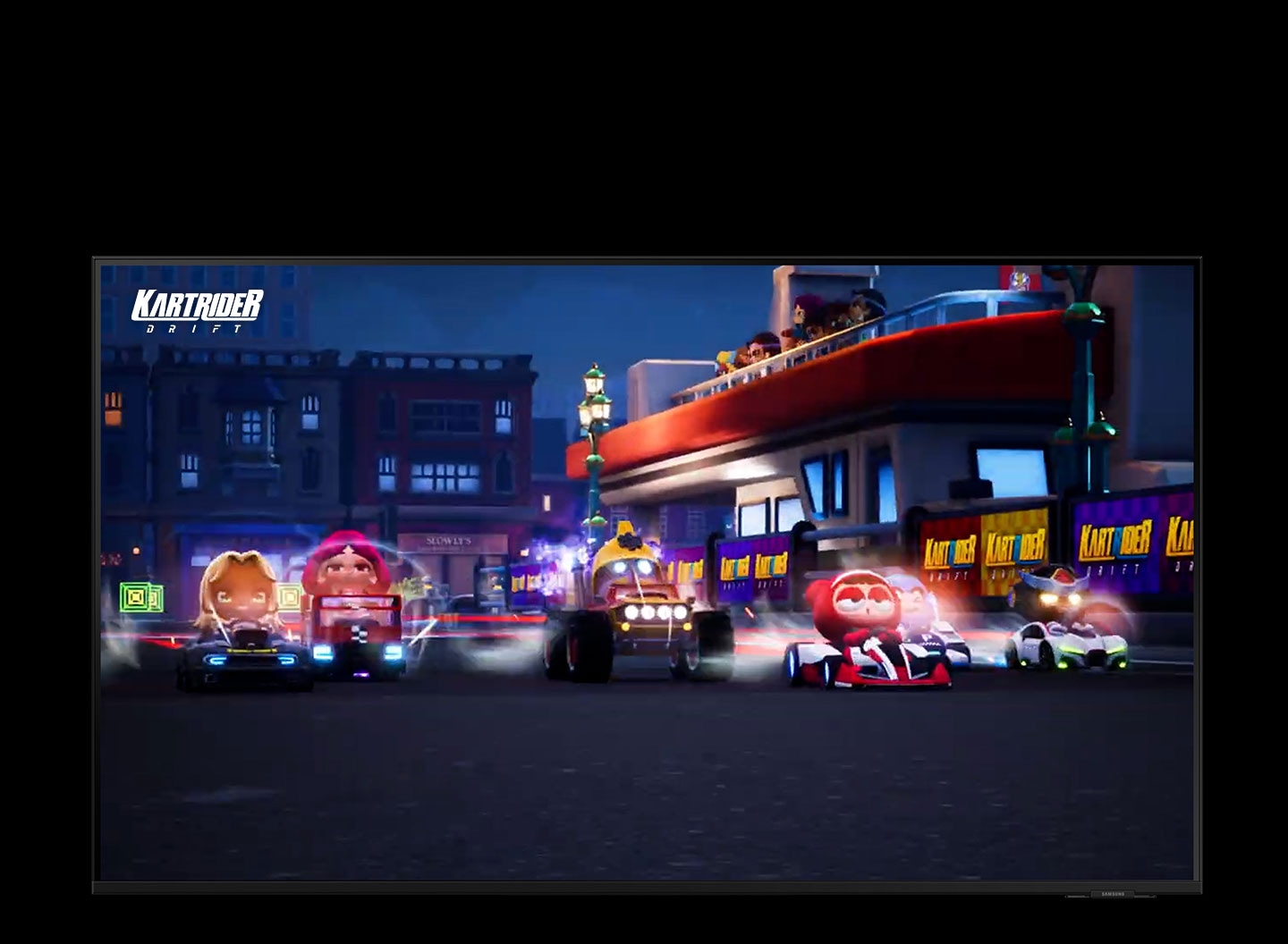 Sechs Fahrerfiguren fahren auf einer Rennstrecke. Um die Spieler herum sind helle Blitze zu sehen, die auf die schnelle Starthilfeleistung hinweisen. Hinter ihnen befinden sich Gebäude und Zuschauer, die den Fahrern zujubeln. An der Wand ist das Logo des Spiels \"Kartrider\" zu sehen.