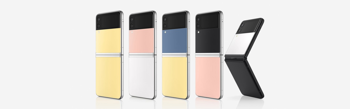 Five Galaxy Z Flip3 Bespoke Editions are arranged into a row, all at a slight angle with their rears facing forward. The first four are fully open, with the fifth being slightly more closed. The color combinations are firstly, Yellow front and back panel with Silver-frame. Secondly, Pink front panel and White rear panel with Silver-frame. Thirdly, Blue front panel and Yellow rear panel with Silver-frame. Fourthly, Black front panel and Pink rear panel with Silver-frame. Fifthly, White front panel and Black rear panel with Black-frame. 