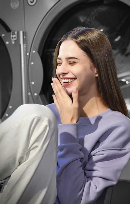 A woman laughing in a laundromat, taken in Portrait Mode with Color Point effect applied.