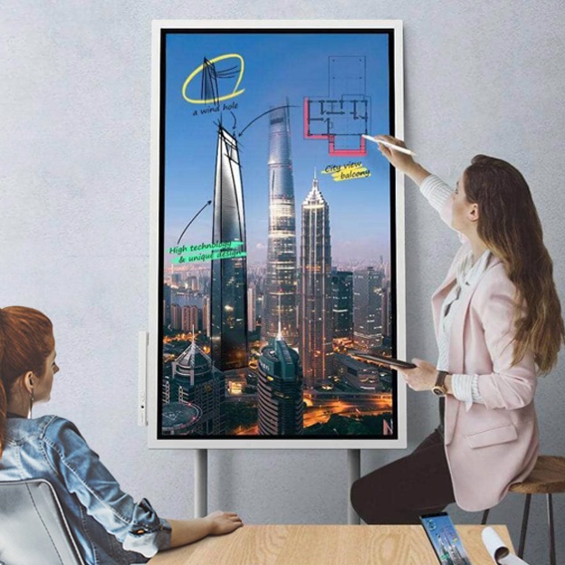 Een afbeelding van een vrouw die een vergadering leidt en schrijft op een Digital Flipcharts. 