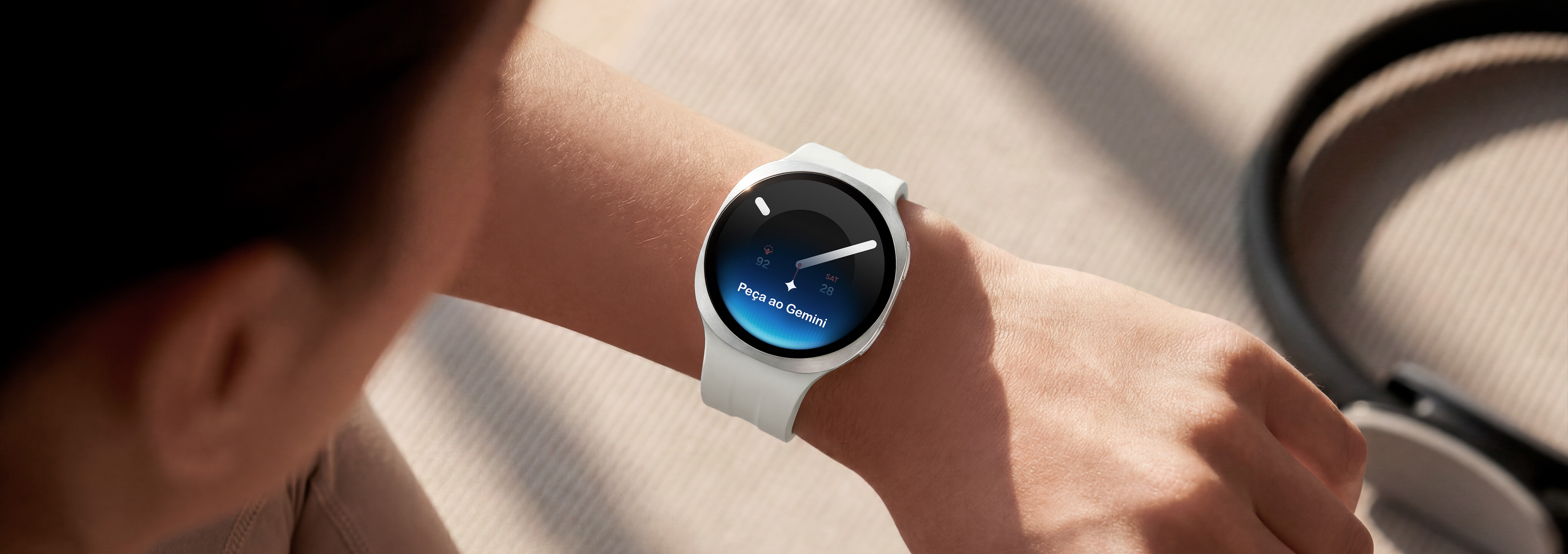 Uma pessoa usando um Galaxy Watch9 em Creme com uma Pulseira Sport em Cream levanta o pulso para dar um comando de voz ao relógio usando o Google Gemini.