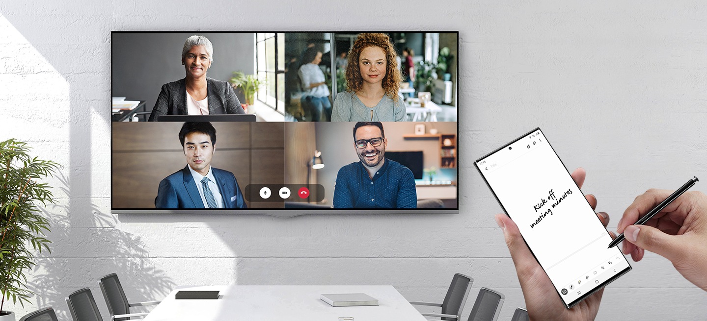 A wall-mounted TV in a meeting room displays a conference call with four people. There are hands holding Galaxy Note20 Ultra with the Samsung Notes app onscreen, and handwriting that says Kick off meeting minutes.