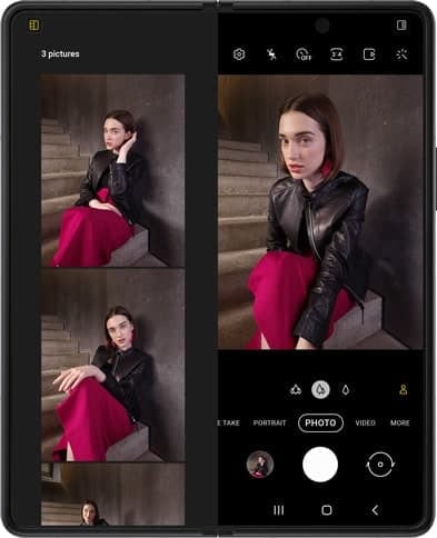 A woman sitting on stairs. Another pose appears, and then another. The photos are floating over unfolded Galaxy Z Fold3 5G. They fall into place the screen inside Capture View Mode in the Camera app. The counter says 2 photos. The shutter snaps and another photo is taken on Galaxy Z Fold3 5G, and the photos shift again to show the bigger view of photos just taken. The counter now says 3 photos.