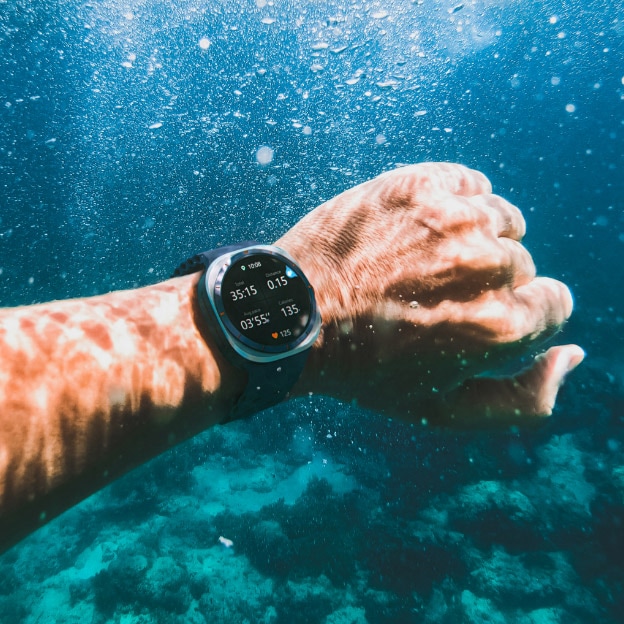 Une main dans l’eau, une montre Galaxy Watch Ultra au poignet.