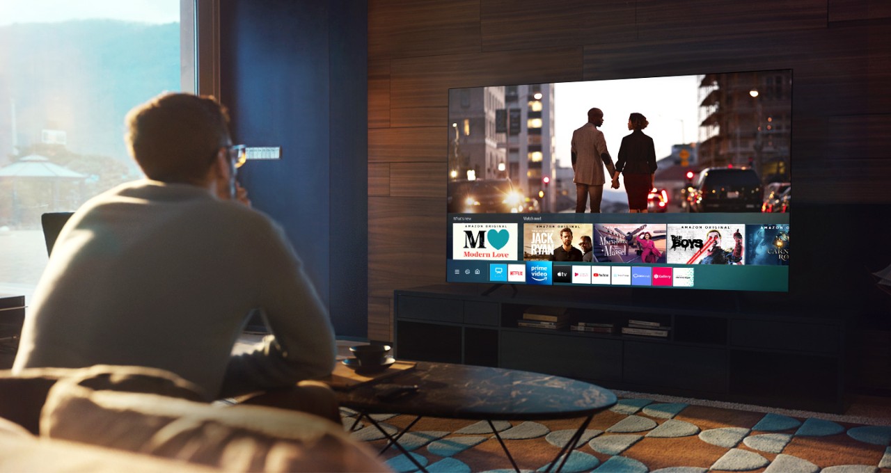Es wird das Samsung Smart Hub Startmenü mit verschiedenen Apps und Vorschaubildern gezeigt.