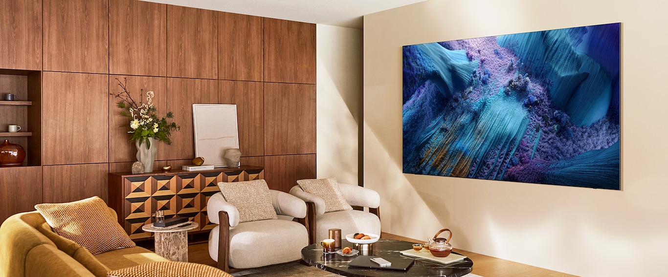 Ein grosser Samsung TV hängt an einer Wand in einem Wohnzimmer. 