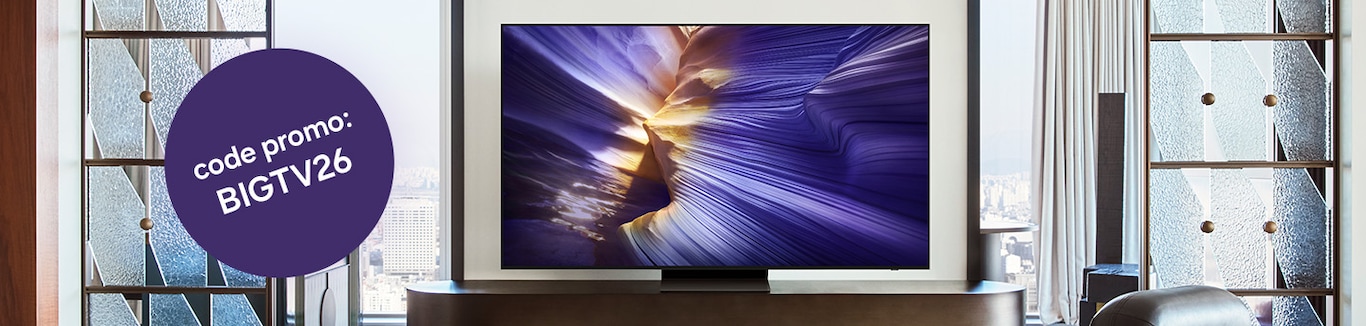 On voit un téléviseur avec des œuvres d'art abstrait en violet et jaune dans un salon moderne avec de grandes fenêtres. Un cercle violet affiche un code de promo : BIGTV26.