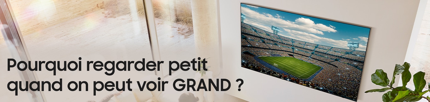 Dans un salon, on voit d'en haut une très grande télévision accrochée au mur. 