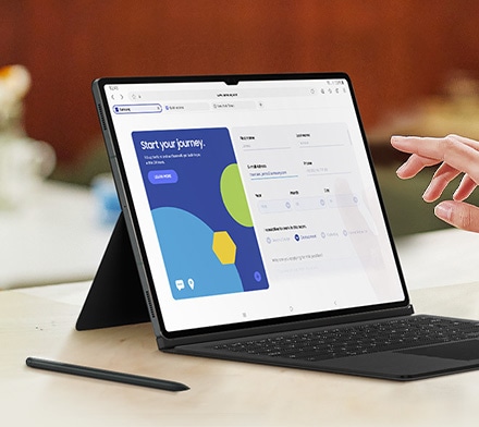 Primer plano de la pantalla de un dispositivo de la serie Galaxy Tab S9 con la Book Cover Keyboard puesta. Una mano está a punto de tocar la pantalla. Se coloca un S Pen junto a la tableta.