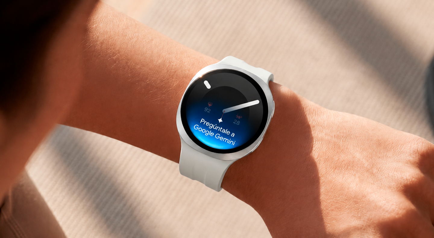 Una persona con un Galaxy Watch9 en Silver y una correa deportiva en Cream levanta la muñeca para dar un comando de voz a su reloj con Google Gemini. En la pantalla del reloj se muestran el icono de Google Gemini y el texto “Pregúntale a Google Gemini.