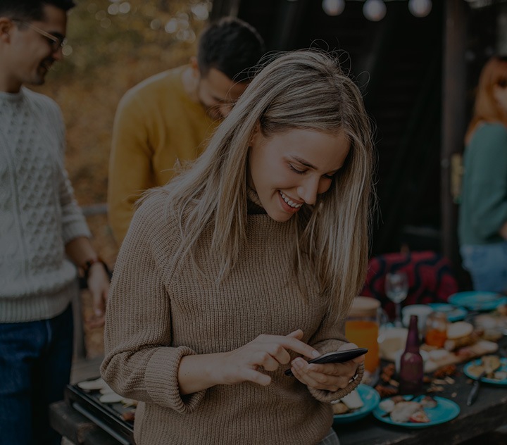 Una pantalla Galaxy muestra un mensaje de texto enviado a Sharon usando las funciones de control de Bixby, leyendo "¿Dónde estás? ¡La fiesta comienza!".