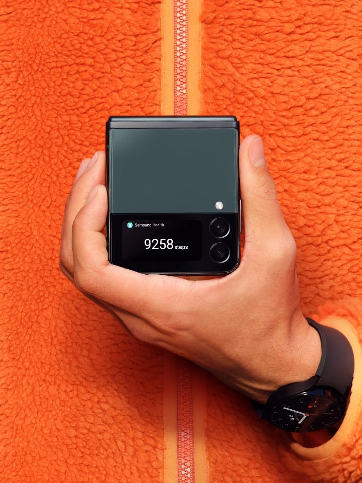 Ruka držící složený Galaxy Z Flip3 5G s počítadlem kroků zobrazeným na vnější obrazovce.