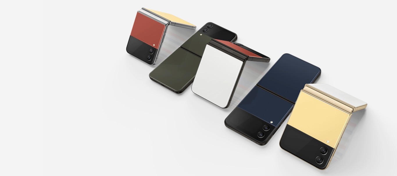 Fünf Galaxy Z Flip4 Bespoke Edition Smartphones sind nebeneinander in einer Reihe angeordnet und leicht von der Seite gedreht zu sehen. Drei Geräte mit zweifarbigen Rückseiten sind im Flex-Modus zu sehen, sodass die Displays nach unten zeigen. Dazwischen befinden sich jeweils zwei Geräte mit einfarbigen Rückseiten, die vollständig aufgeklappt auf ihren Displays liegen. 