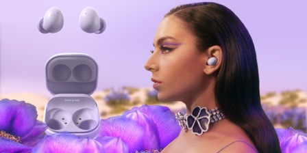 " Man sieht Charli XCX, die Galaxy Buds2 in Lavender vor einem Hintergrund mit lila Blumen und schwebenden Lavender Galaxy Buds2 trägt."