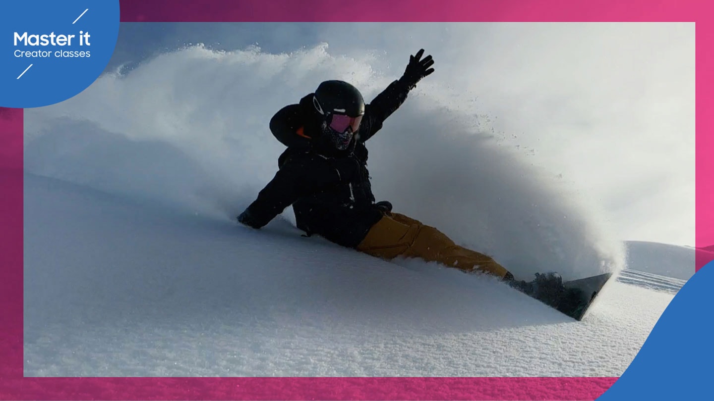 En snowboarder suser ned ad et snedækket bjerg på en skyet dag og sender en tyk fane af perfekt puddersne op, mens han læner sig ned for at svinge. Master it. Creator classes.