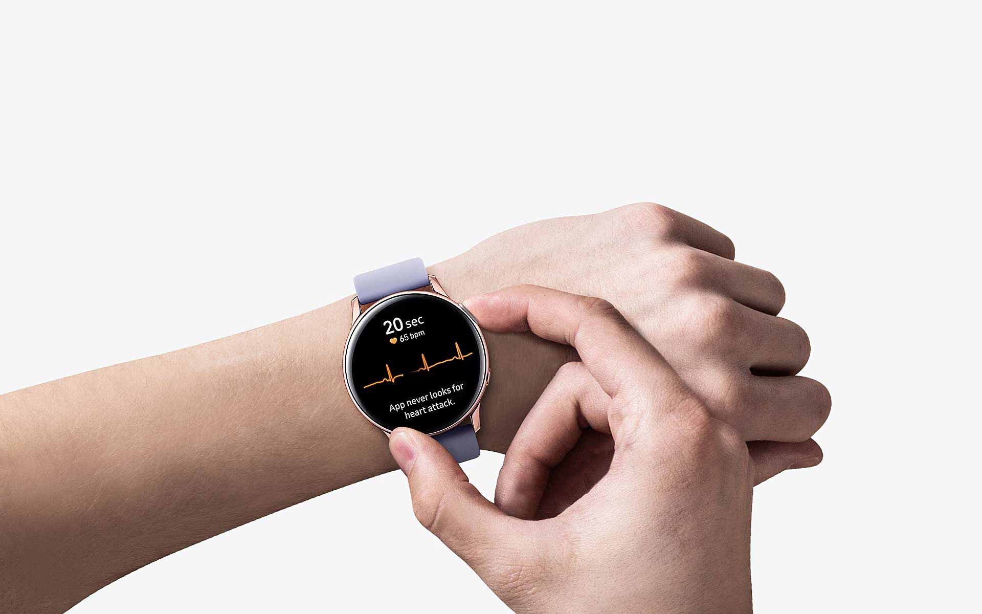A person wears the Black Galaxy Watch Active2 with only their arms showing. A hand presses a button on the watch's side, and ECG measurements are shown on the watch face.