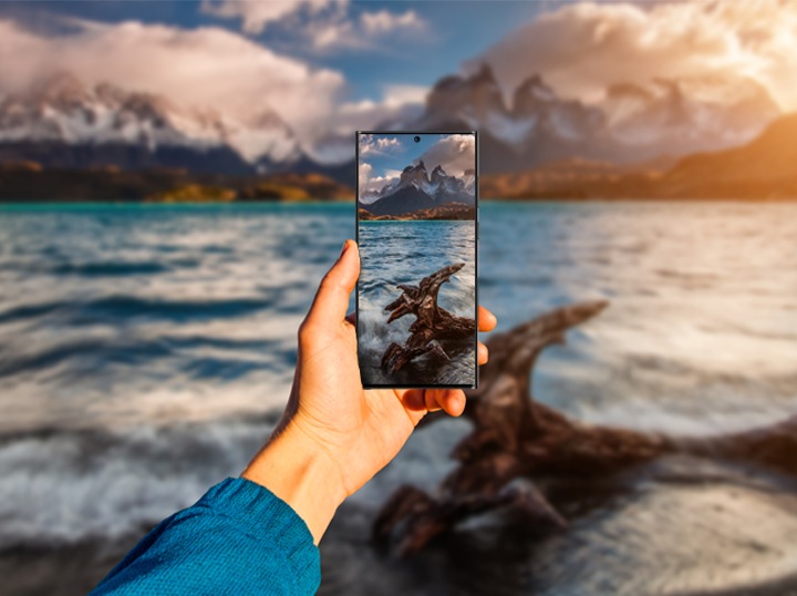Mees teeb ookeani lähedal oma mobiiltelefoniga merest pilti.
