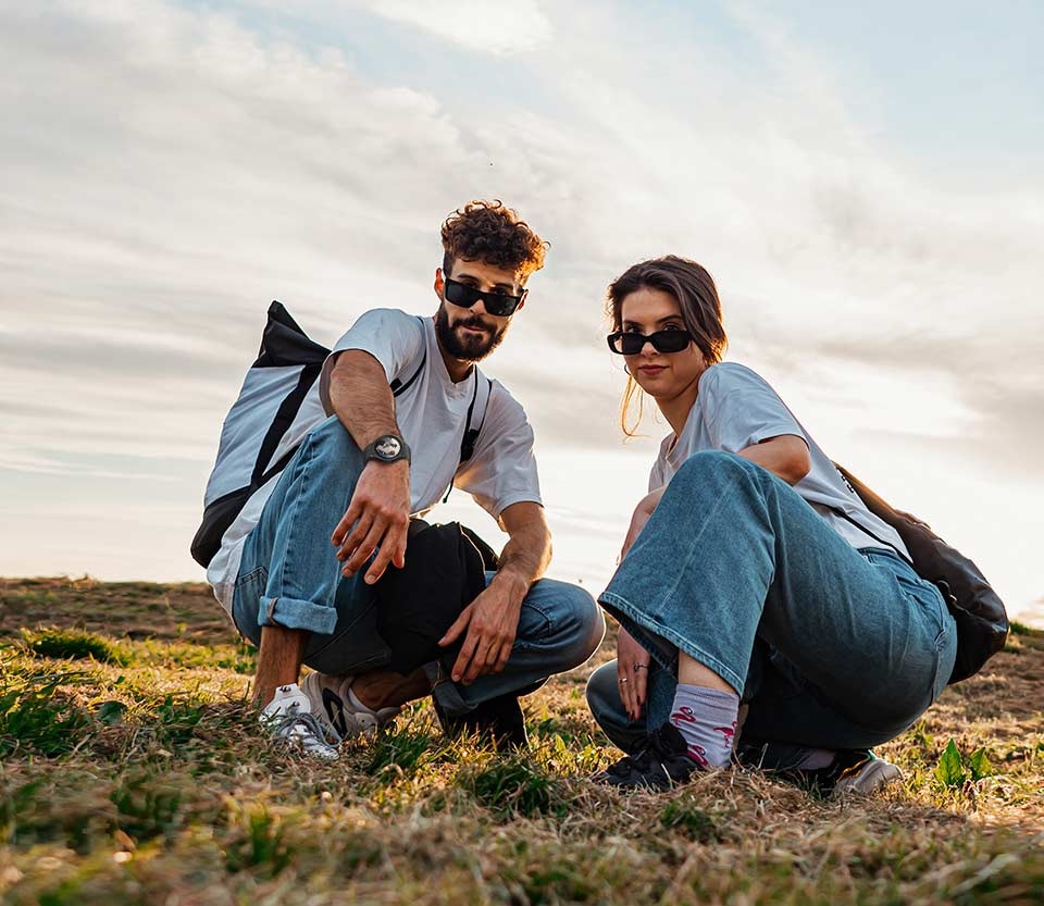 Two people pose for a low-angle photo from a distance using the Galaxy Watch5 Pro to control the smartphone camera.