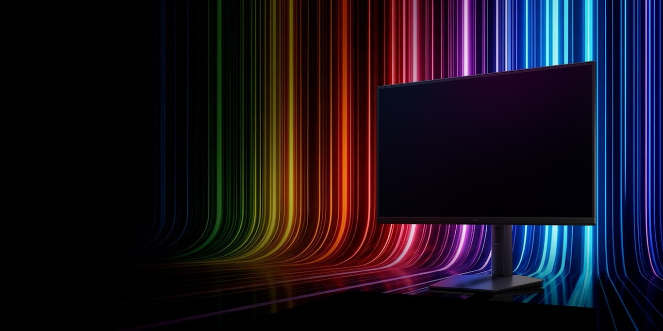 Monitor Samsung en silueta oscura sobre un destello de luces arcoíris en el fondo.