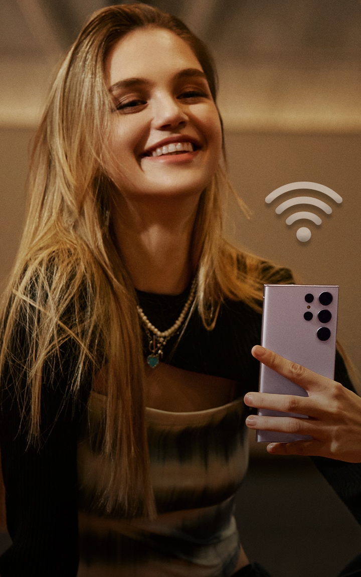 Imagen de  persona usando un teléfono móvil y un icono de wifi en medio