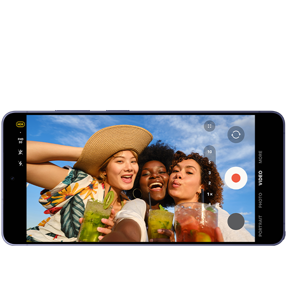 Älypuhelimen näytöllä näkyy videon tallennusnäkymä. Näytöllä näkyy kolme naista juomat kädessään.