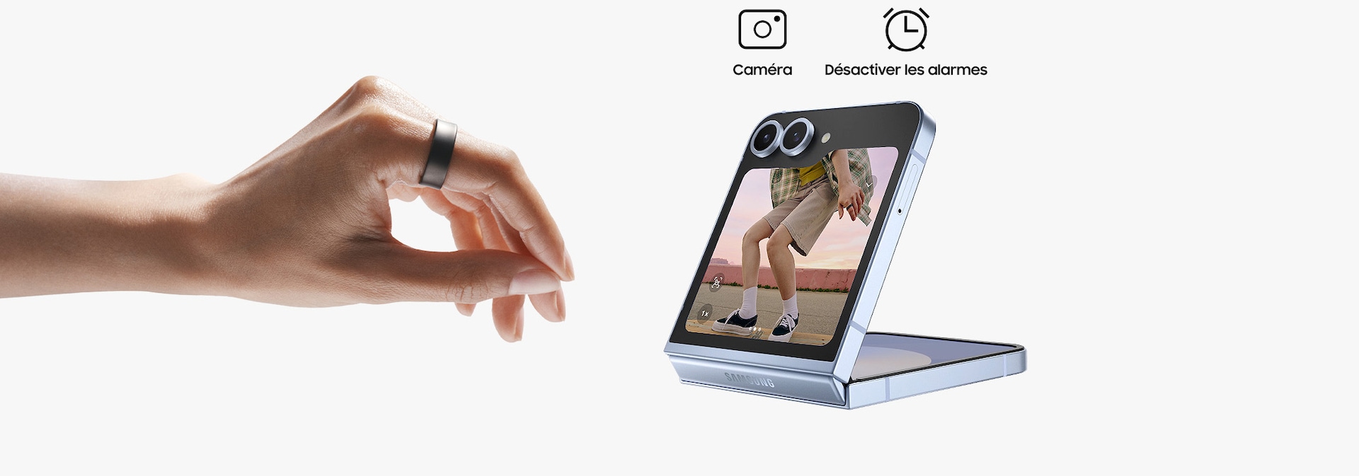 A hand wearing Galaxy Ring can be seen, making a pinching motion. A closed Galaxy Z Flip6 with the camera open on the cover screen can be seen. Above the smartphone are two icons: Camera and Turn off alarms.