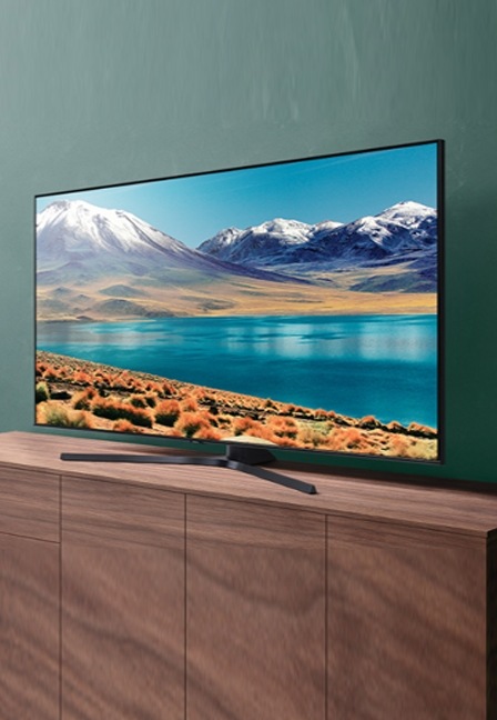 Samsung Crystal UHD TV est placé sur la table affichant le lac et la montagne avec de la neige