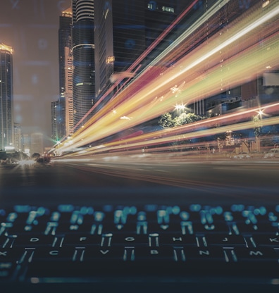 An image of a fast-paced light is expressed in a city photo, and a keyboard is combined in front of it.