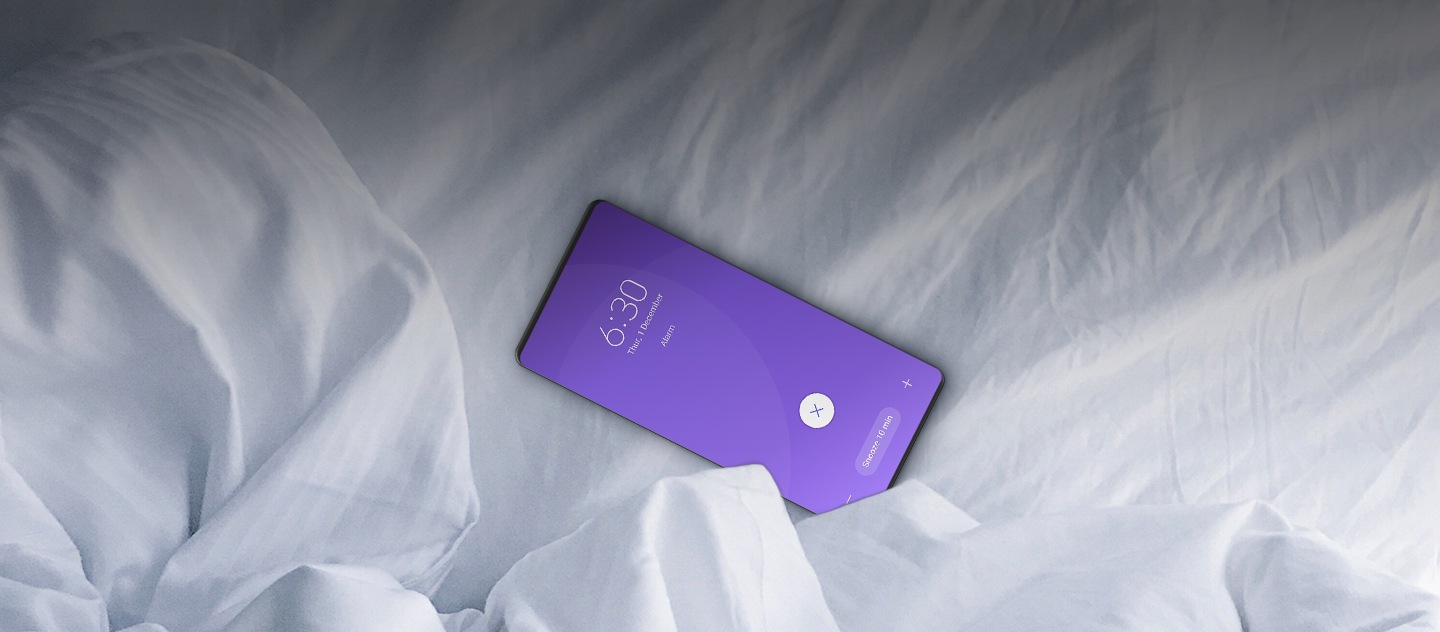 Ένα smartphone Galaxy σε λευκά σεντόνια με το ξυπνητήρι 6:30 π.μ να χτυπάει.