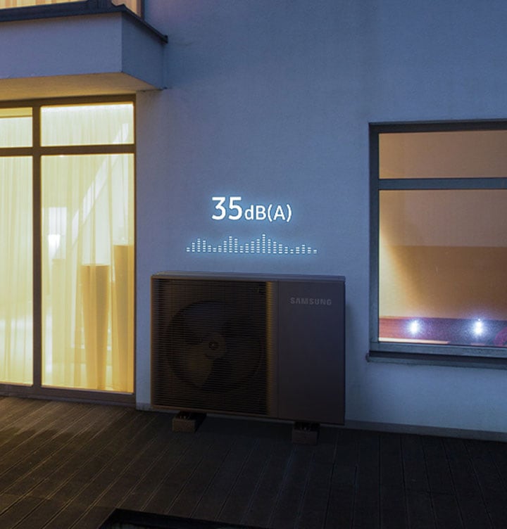 Stylish designed house with the lights turned on and a black outdoor unit