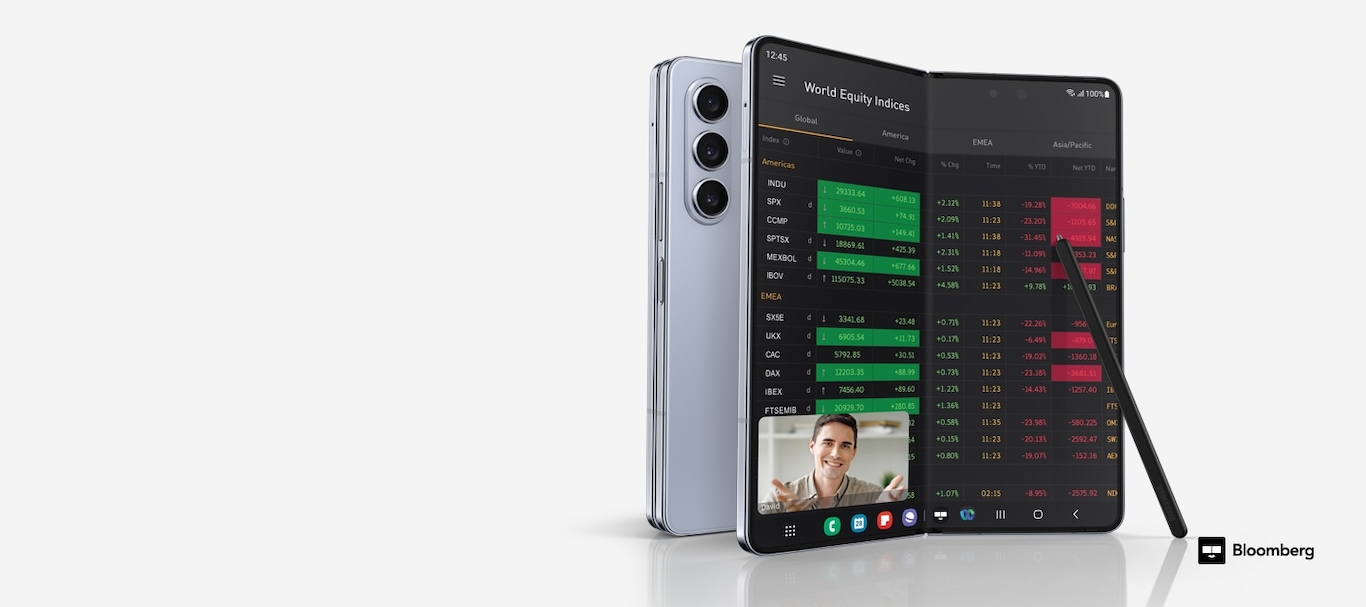 兩部Galaxy Z Fold5 手機，一部折疊起來並從後面看到，另一部展開並從主屏幕上看到，主屏幕上顯示了彭博應用程序中的世界股票指數，頂部的浮動窗口中打開了視頻通話。 Galaxy Z Fold5 的 S Pen Fold 版本靠在顯示屏上。 彭博社標誌。