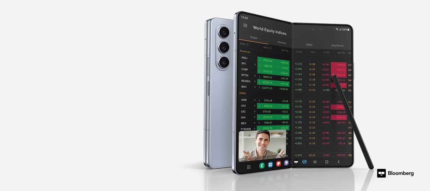 Dua ponsel Galaxy Z Fold5, satu dilipat dan dilihat dari belakang, yang lainnya dibuka lipatannya dan dilihat dari Layar Utama, yang menampilkan indeks ekuitas dunia pada aplikasi Bloomberg, dan panggilan video terbuka di jendela mengambang di atasnya. S Pen Fold Edition untuk Galaxy Z Fold5 bersandar pada tampilan. Logo Bloomberg.