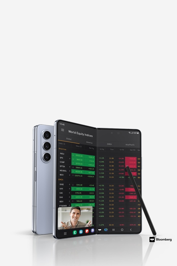Dua ponsel Galaxy Z Fold5, satu dilipat dan dilihat dari belakang, yang lainnya dibuka lipatannya dan dilihat dari Layar Utama, yang menampilkan indeks ekuitas dunia pada aplikasi Bloomberg, dan panggilan video terbuka di jendela mengambang di atasnya. S Pen Fold Edition untuk Galaxy Z Fold5 bersandar pada tampilan. Logo Bloomberg.