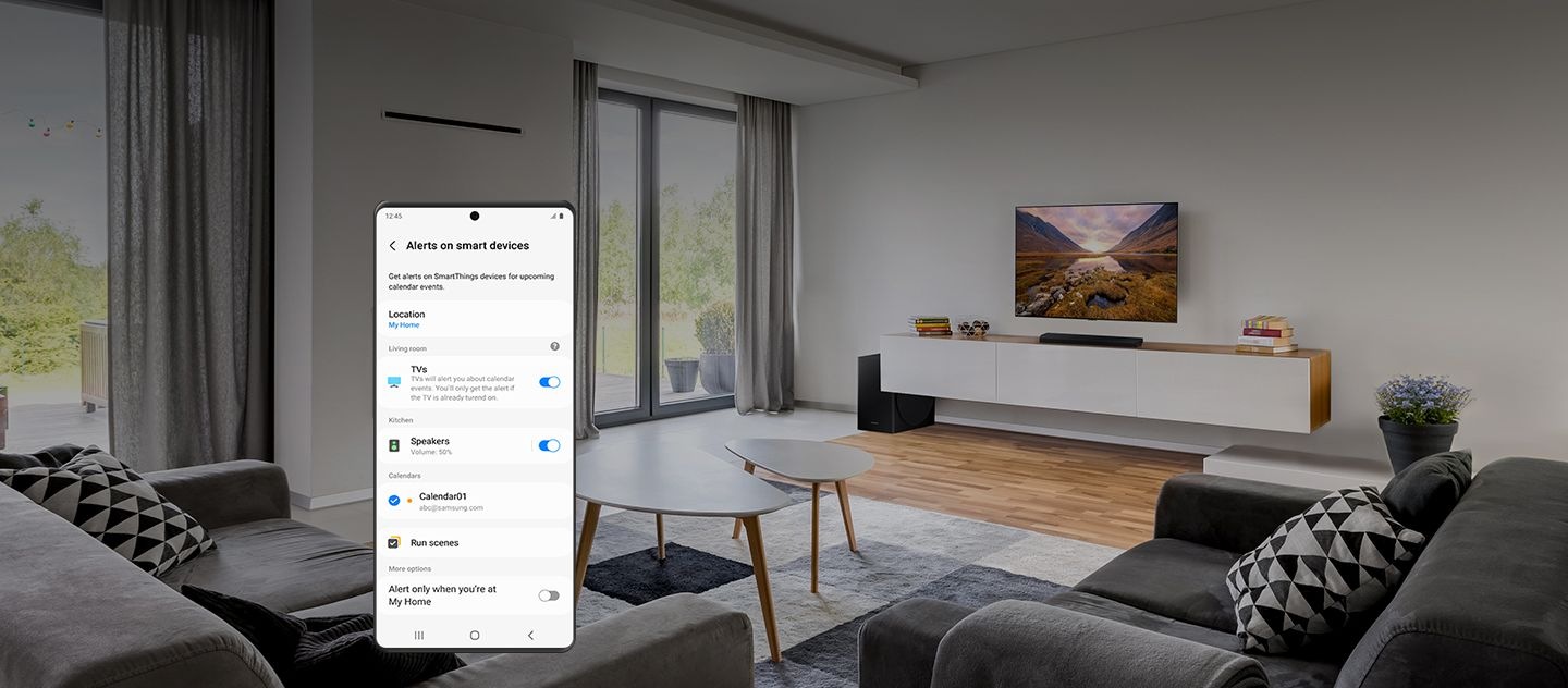 In the background, an interior of a clean living room with sofas, TV, and more. In the foreground, a Galaxy smartphone shows the settings menu for "Alerts on smart devices."