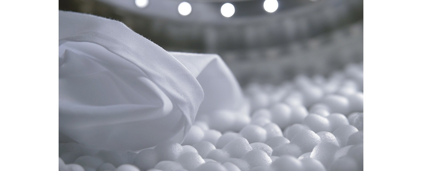 Eco bubbles that protect fabric color and texture of the white shirt, are emerging from the drum of the new Samsung washer.