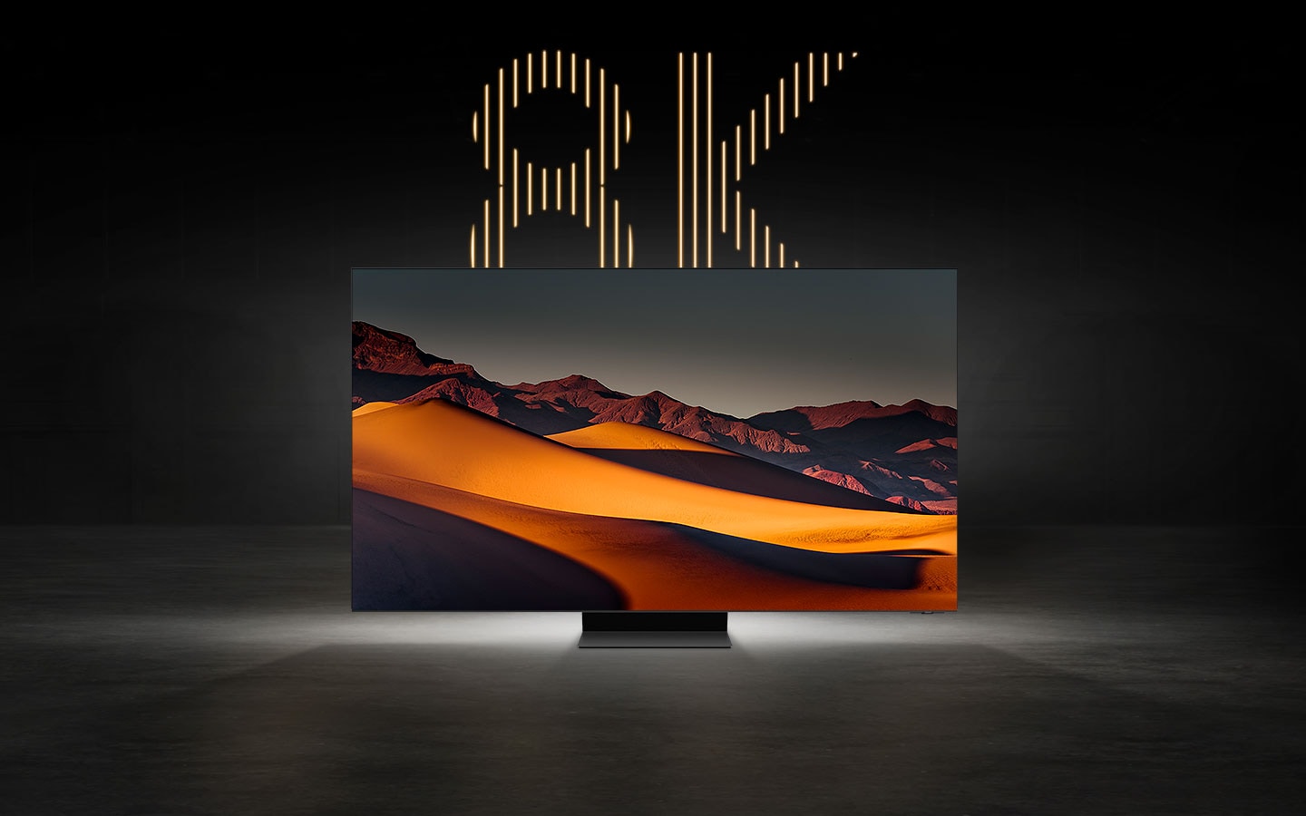Un TV 8K mostra l’immagine mozzafiato di un deserto montuoso, con la scritta “8K” ben visibile dietro lo schermo.