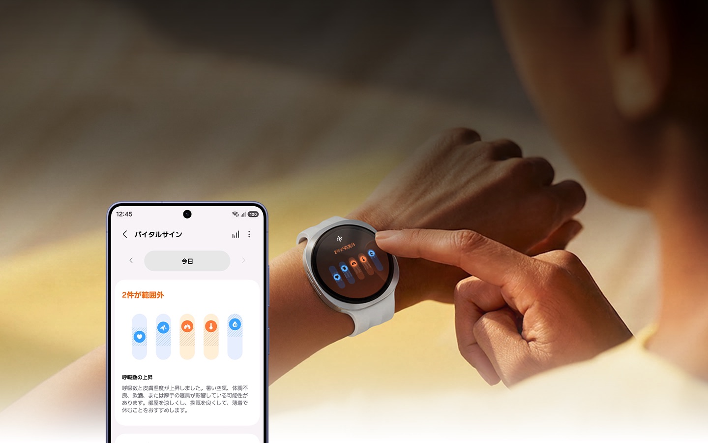 女性がGalaxy Watchに触れている。時計の画面には、「2件が範囲外」というテキストと呼吸数の上昇を示すアイコンが表示されている。下部には「呼吸数と皮膚温度が上昇しました。暑い空気、体調不良、飲食、または厚手の寝具が影響している可能性があります。部屋を涼しくし、換気を良くして、薄着で休むことをおすすめします。」というテキストが記載されている。