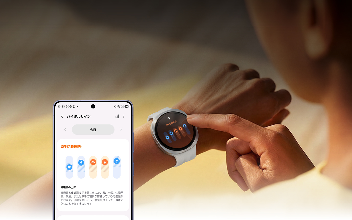 女性がGalaxy Watchに触れている。時計の画面には、「2件が範囲外」というテキストと呼吸数の上昇を示すアイコンが表示されている。下部には「呼吸数と皮膚温度が上昇しました。暑い空気、体調不良、飲食、または厚手の寝具が影響している可能性があります。部屋を涼しくし、換気を良くして、薄着で休むことをおすすめします。」というテキストが記載されている。