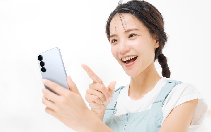 Samsung Galaxy S25（サムスンギャラクシーエス25）で鼻歌検索をした結果が出て驚いている女性。