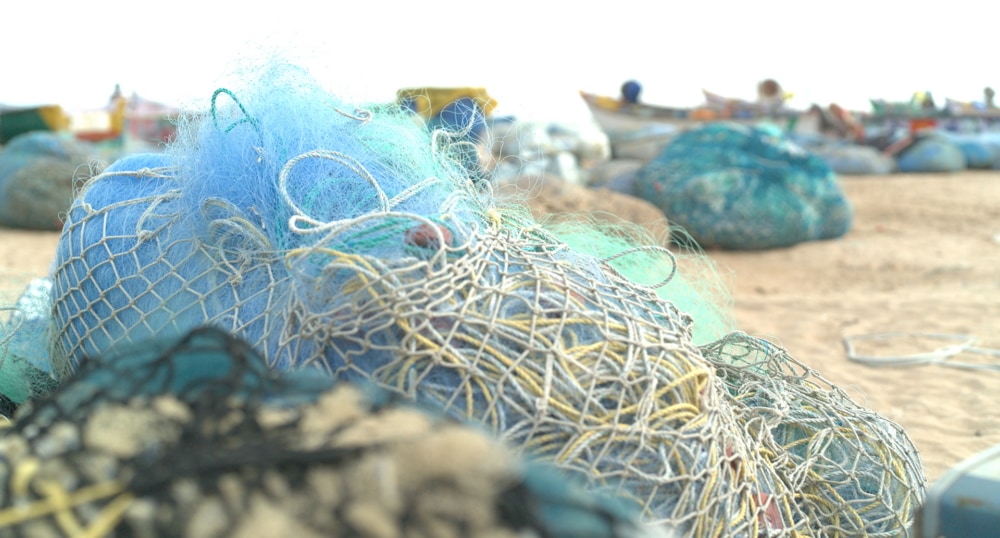 湖の辺に回収した多くの漁網が置かれている。