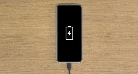  机上に置かれたGalaxy（ギャラクシー）スマートフォン。近くにはタイプCの充電ケーブルが置かれている。