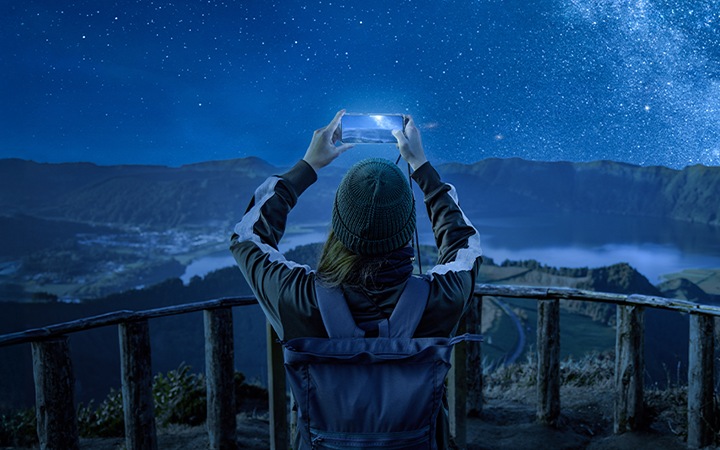 [展望台で星空を撮影している女性の画像。]
