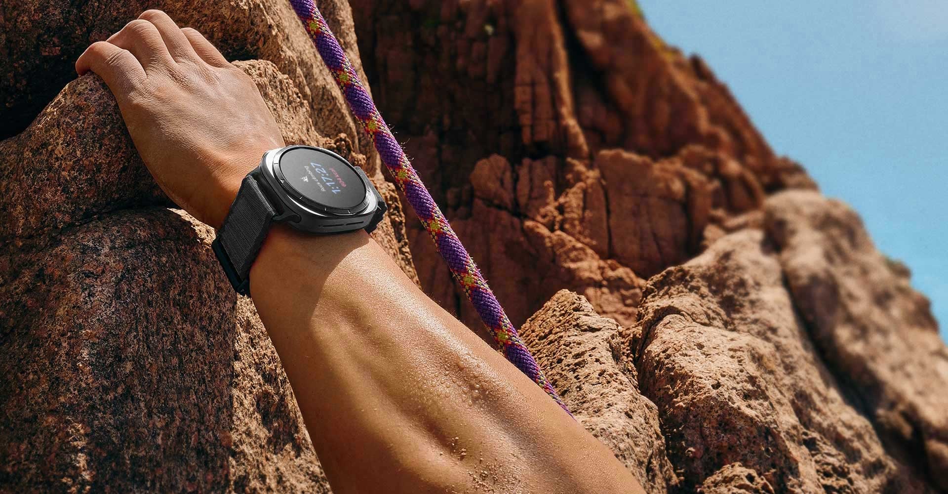 山の岩をつかんでいる手が、手首にGalaxy Watch Ultraを装着している。
