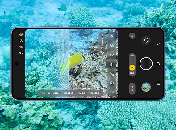 水中のシーンを背景に、横向きに置かれたコバルト バイオレットのGalaxy S26 Ultra。メインディスプレイにExpert RAWアプリが表示され、水中のシーンを撮影している。線は、元の写真と最適化された写真の違いを示している。最適化された写真では、青みが除去され、鮮明でリアルな色だけが残る。