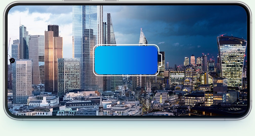 Galaxy S22 plus с городским пейзажем на экране. Значок батареи находится спереди, а городской пейзаж меняется от дня к ночи, чтобы продемонстрировать, что батарея работает в течение всего дня.