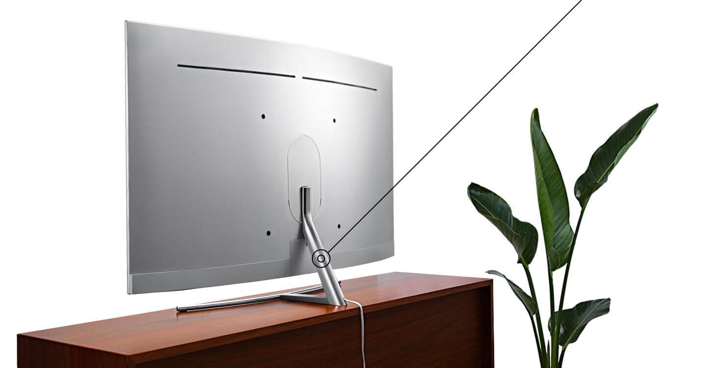There is QLED TV on the timber shelf with its back and at the tip of the stand, power cable is connected.