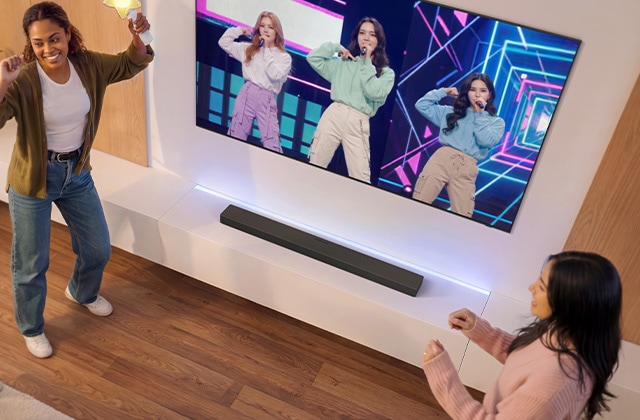 Friends dancing in front of a TV