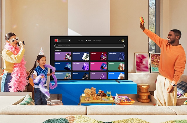 Family singing karaoke in front of a TV