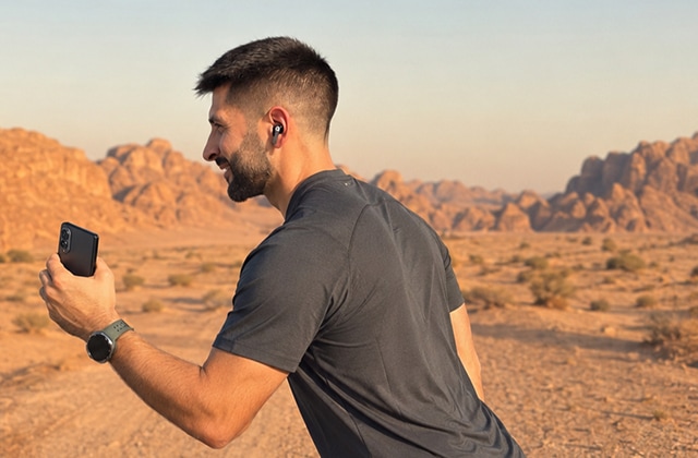 Man checking his phone while running outdoors
